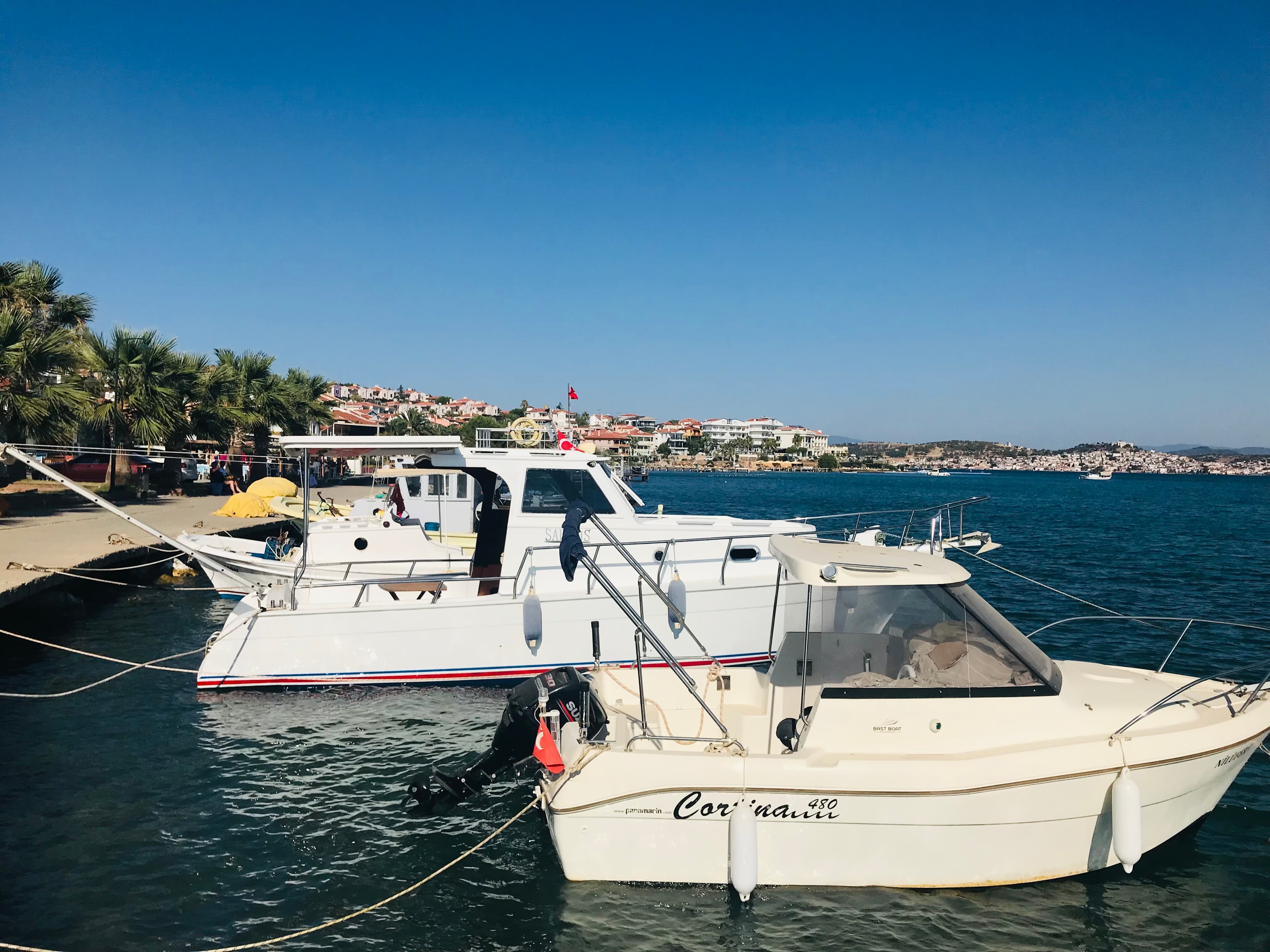 Cunda Adası'nın tarihi taş evleri ve rengarenk tekneleri, gün batımında.